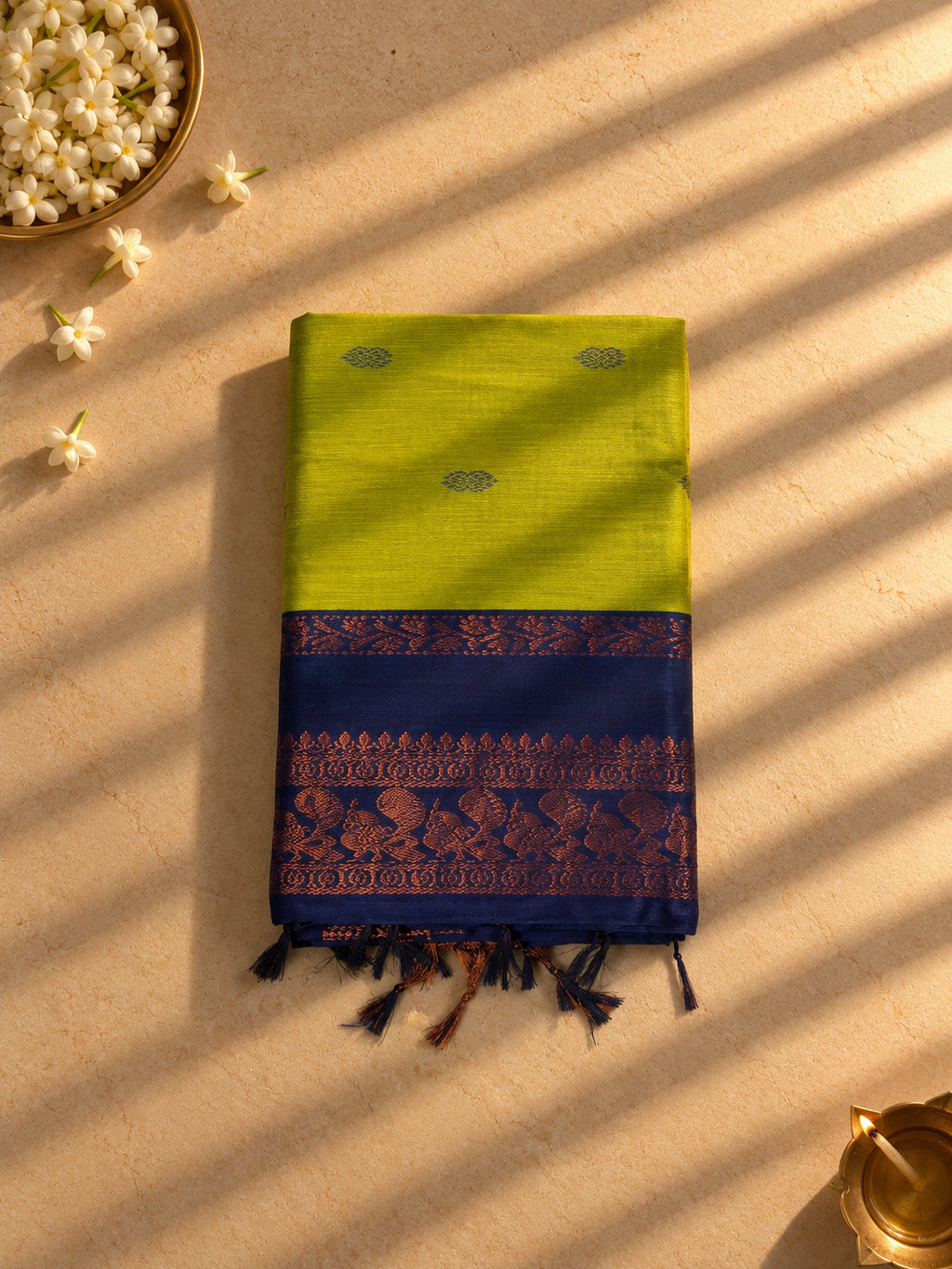 Lime green Gadwal cotton saree with navy peacock border, folded