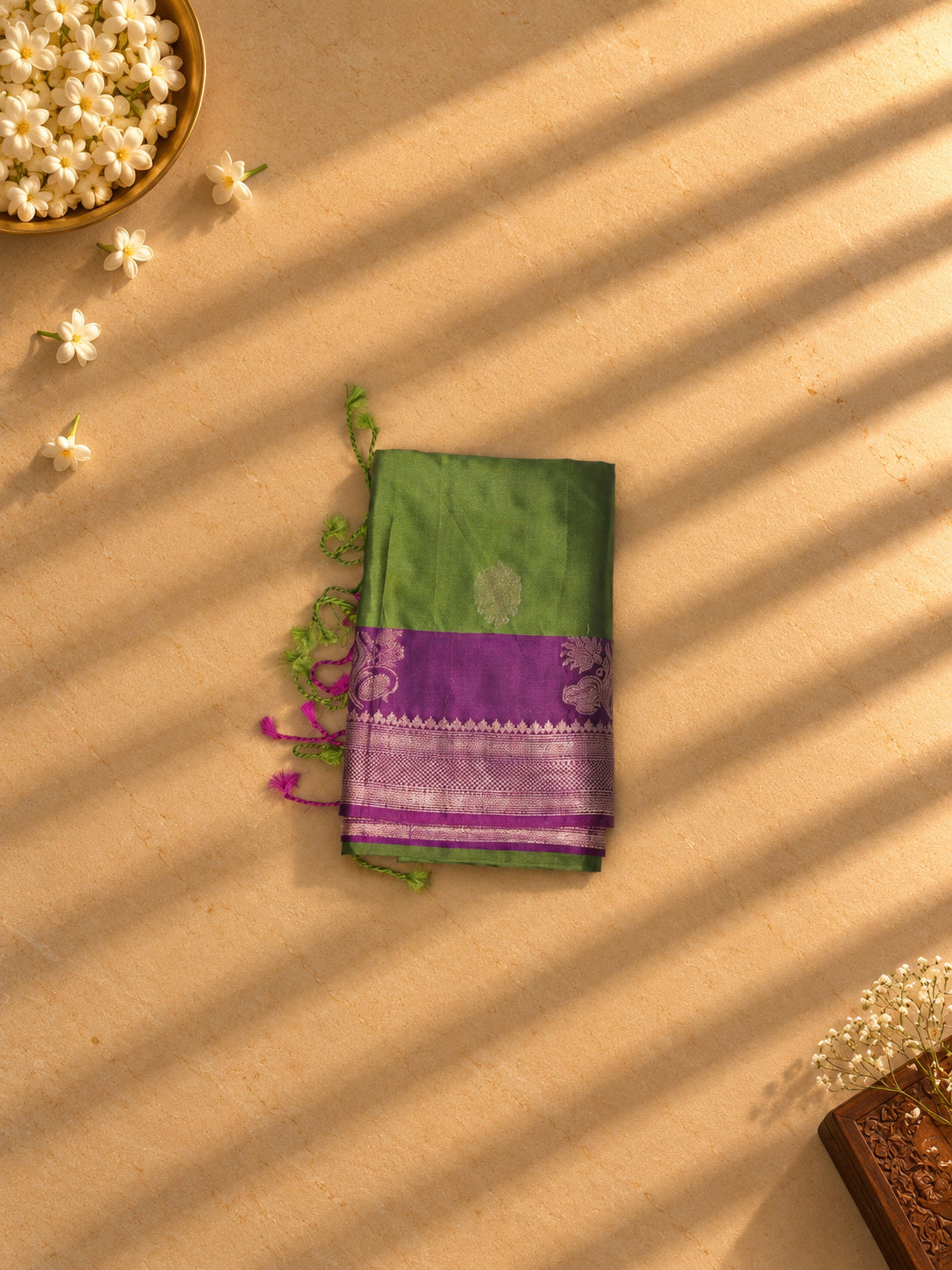 Olive green soft silk saree with purple and silver zari border, folded