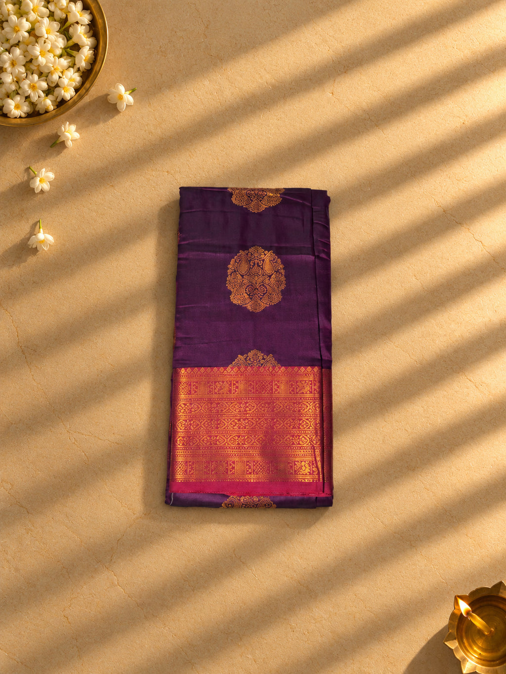 Purple semi silk saree with rani pink and gold zari border, folded